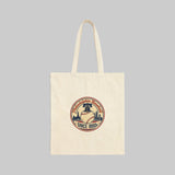 Beige tote bag with a decorative emblem on a white background